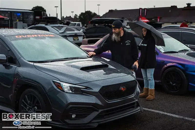 Don and Missy with the car in the rain at Boxerfest, Overtake banner on