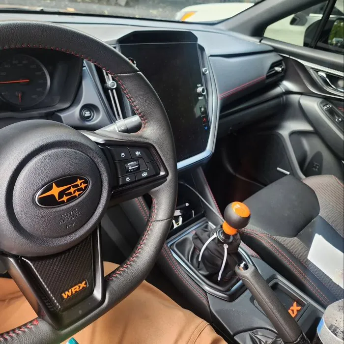 AeroflowDynamics orange steering wheel logo and WRX lettering
