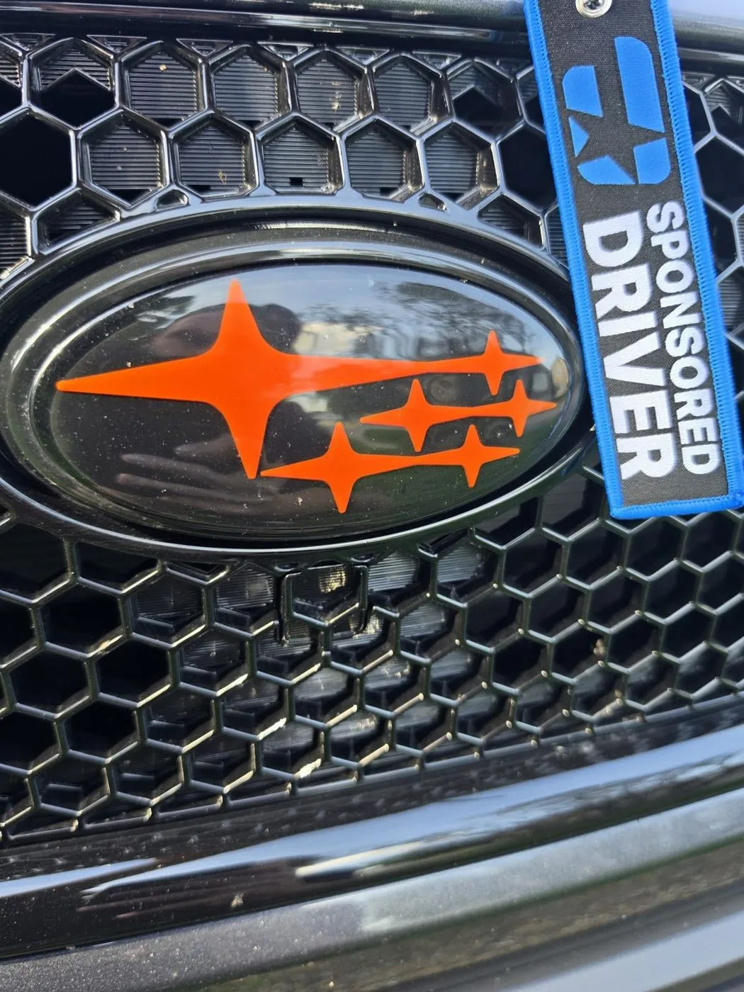 Orange badge with the Sponsored Driver tag