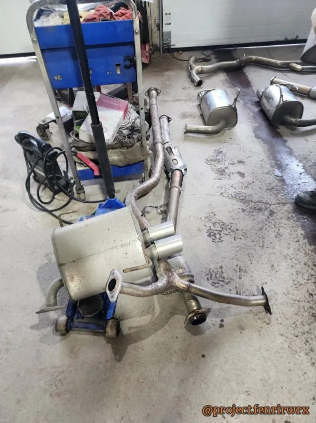 The pile of stock exhaust parts on the shop floor