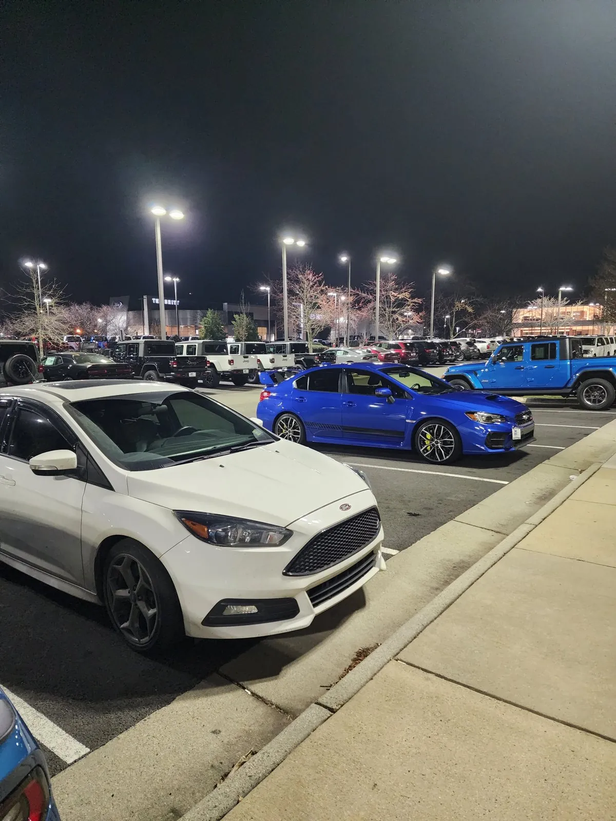 Trade-in night, March 2023: the white Focus ST beside the blue STI
