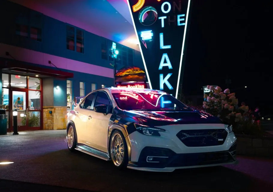 @inkd.wrx's WRX under a neon sign at night